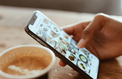 person holding a phone with a coffee